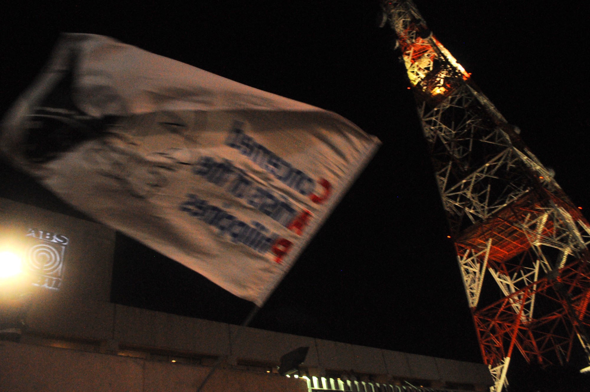 A flag of the progressive artists' group Concerned Artists of the Philippines or CAP waves over the crowd and under the network tower. 
